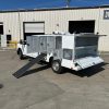 Diamond 8-foot animal transport body with stainless steel cages, A/C roof ducting, LED lighting, and rear step bumper installed on a Ford chassis.