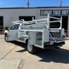 Custom white steel service body on Chevy 3500 with ladder rack and pull-out drawers