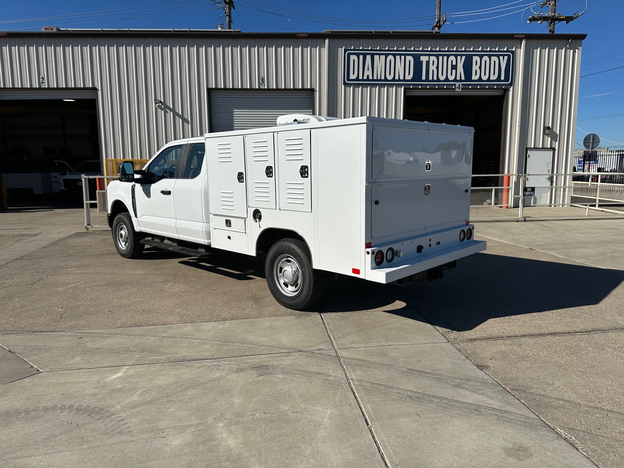 8-foot Diamond Animal Transport Body installed on a Ford F-250 Super Cab chassis, painted white and designed for county animal control use.”