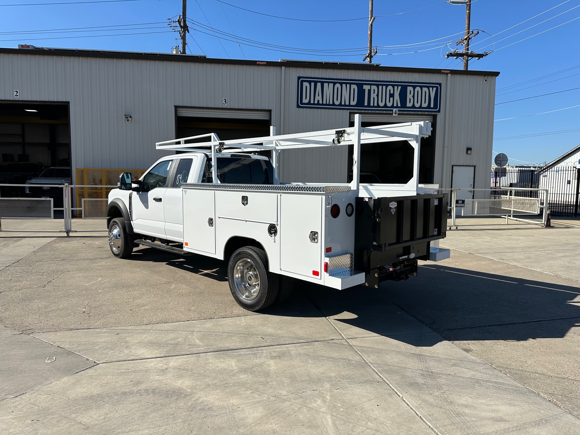 9-foot Diamond service body mounted on a 2026 Ford F-450 60-inch CA chassis, painted white with open-top compartments and aluminum diamond overlay lids.”