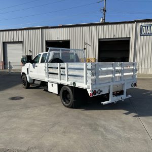 Heavy-duty Chevrolet 5500 flatbed truck body with 30K hitch, steel diamond plate deck, underbody toolboxes, and LED work lights