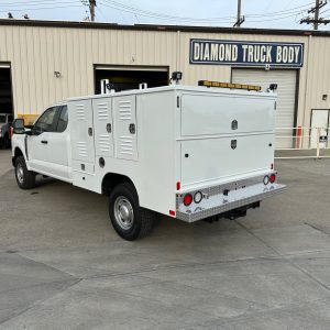 side view of in stock animal control truck body with aluminum compartments and louvered cage doors
